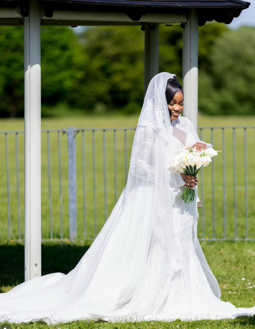 Bride in a beaded lace gown with a full-length veil and calla lily bouquet, photographed outdoors by Surge Pixels
